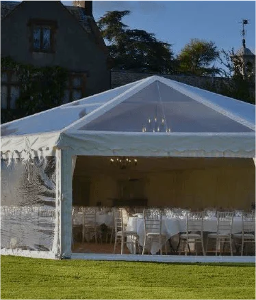 Clear-sided marquee with rows of dining chairs
