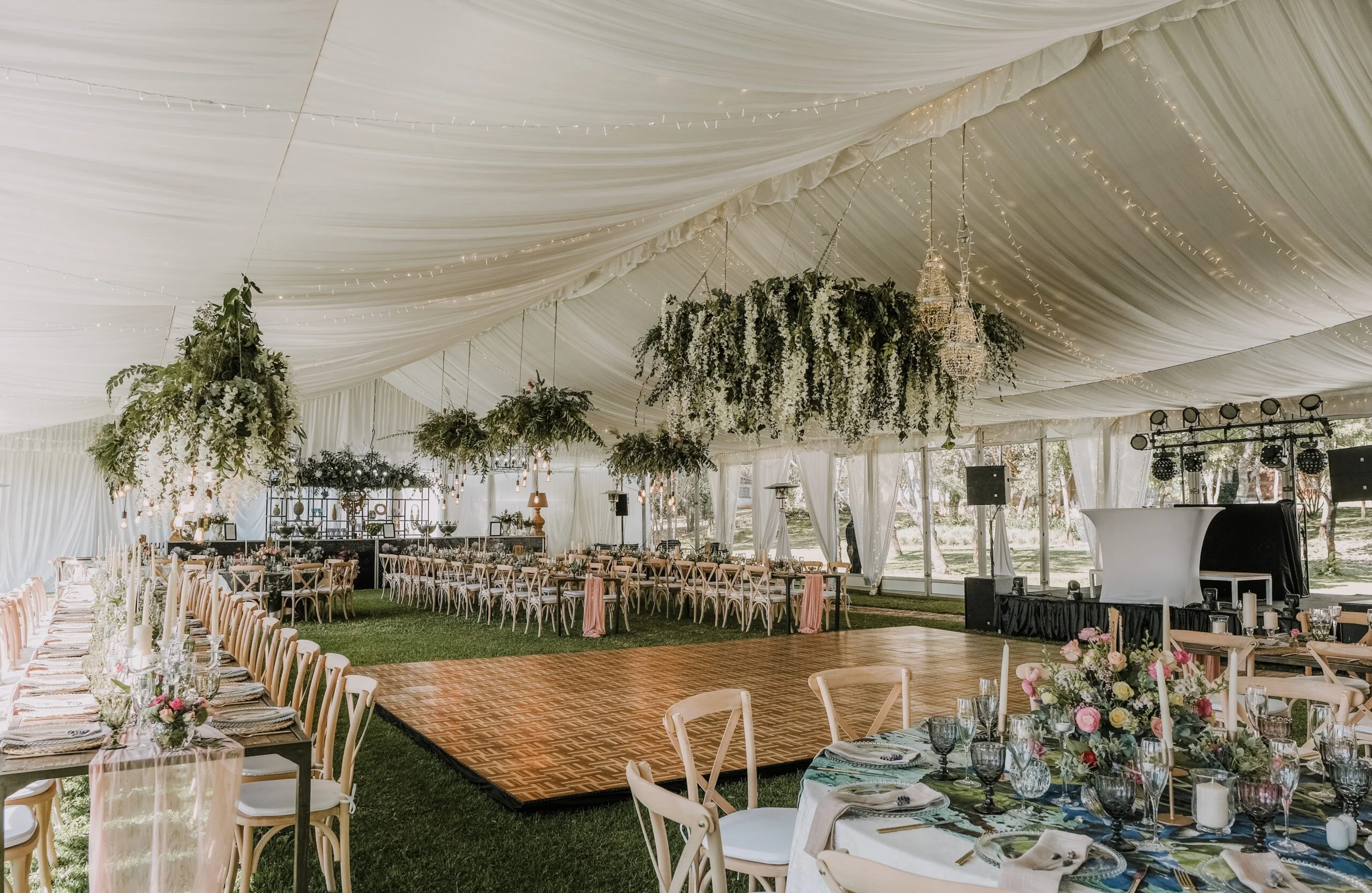 Marquee interior with dining tables and hanging greenery