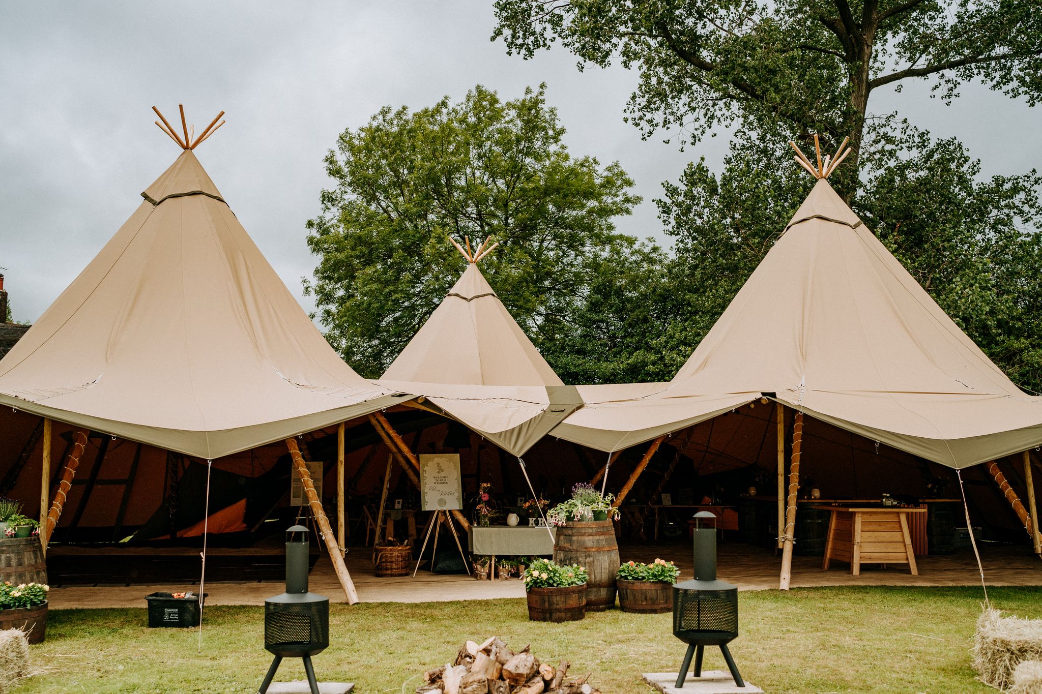 Linked tipis arranged around an outdoor seating area — example for events in Staffordshire