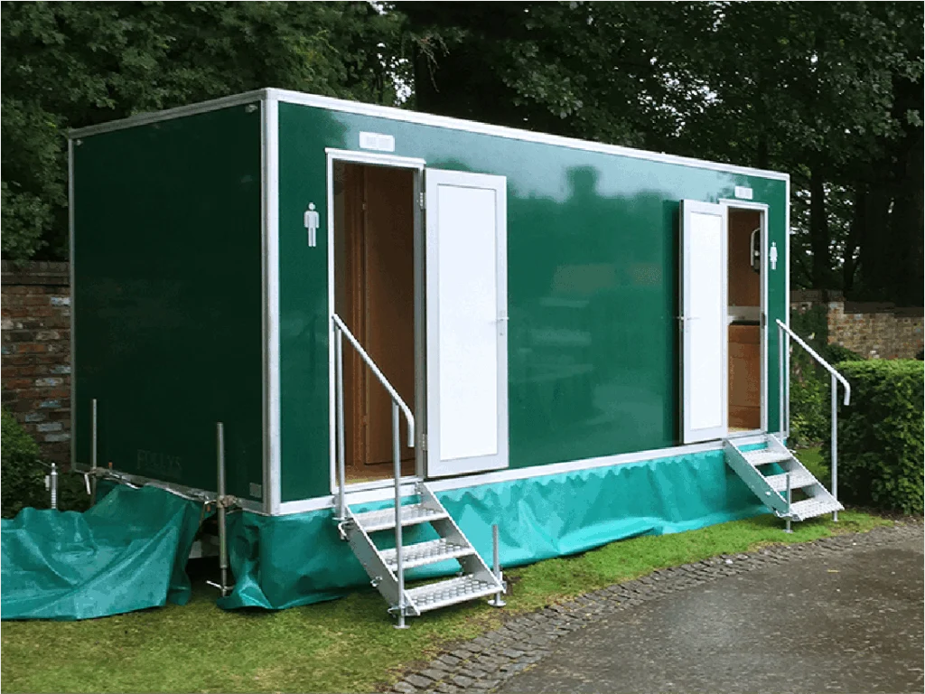 Green mobile toilet trailer with access steps