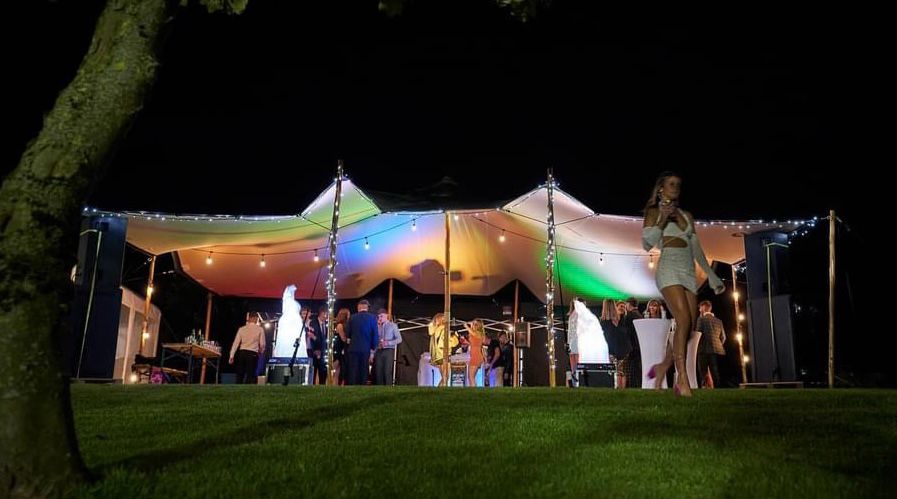 Stretch tent illuminated with coloured lights at night — example for events in Congleton