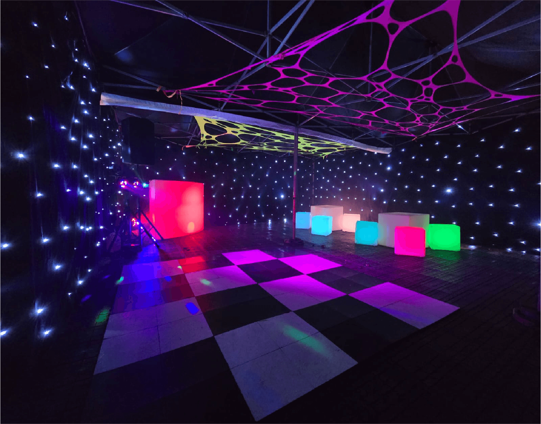 Party tent with a chequered dance floor and colourful lighting — example for events in Alderley Edge